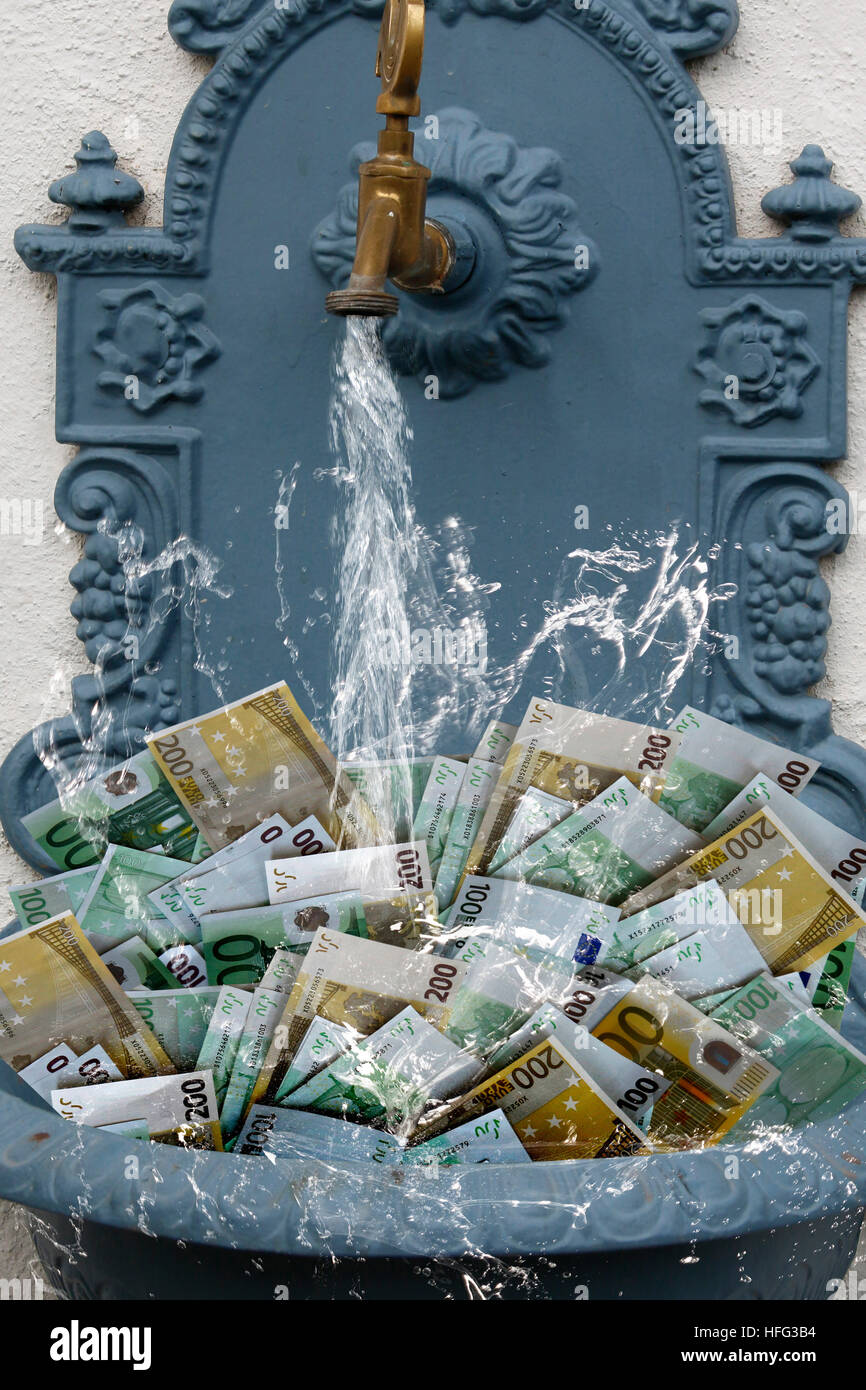 Falschgeld in Brunnen mit Wasser laufen, Symbolik Stockfoto