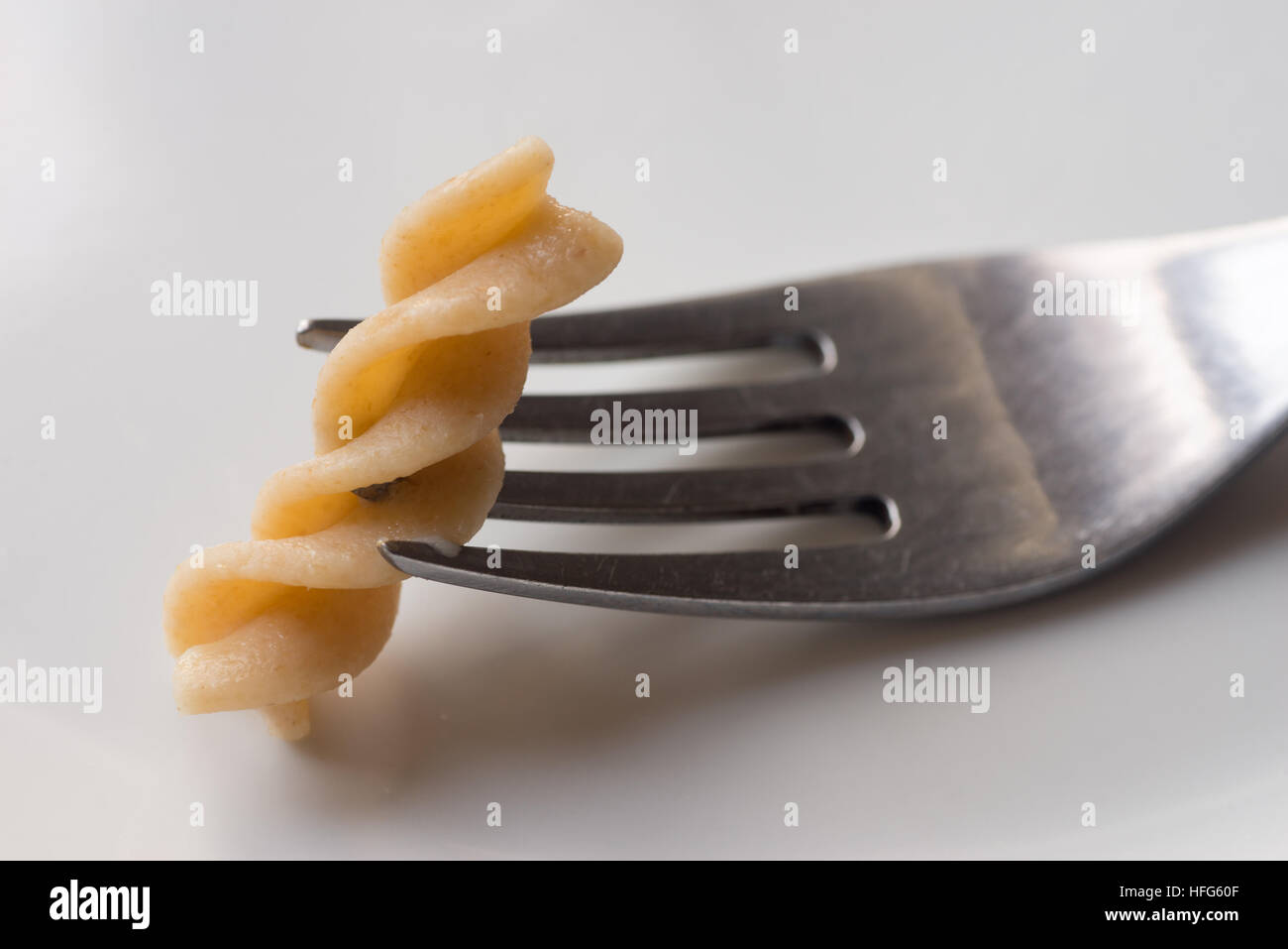 Stück der Pasta auf Gabel auf weißen Teller Stockfoto