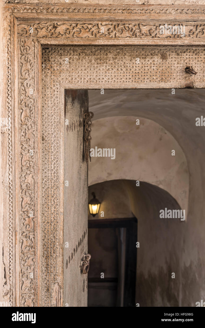Offene Tür in Nizwa Fort, im Sultanat Oman. Sehr schöne Details von der ursprünglichen Holztür sind sichtbar. Stockfoto