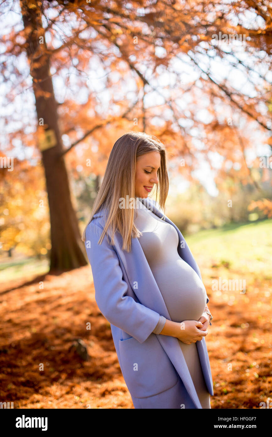 Schöne schwangere Frau im Freien, mit Freude erwartet, das Baby glücklich Schwangerschaft Zeit Stockfoto