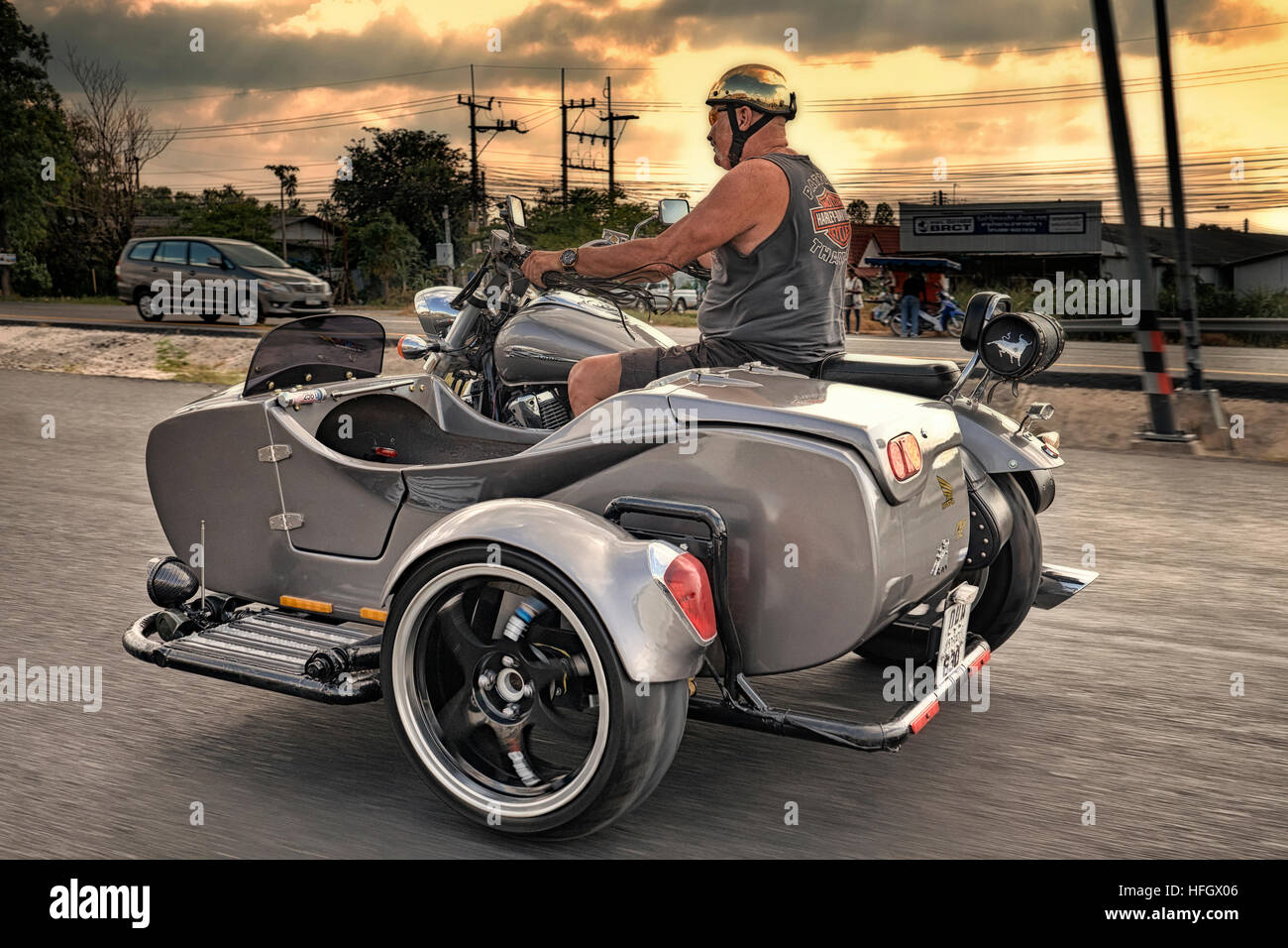 Motorrad-Beiwagen. Motorradfahrer, der maßgeschneiderte Motorrad- und Beiwagen entlang der Straße fährt Stockfoto