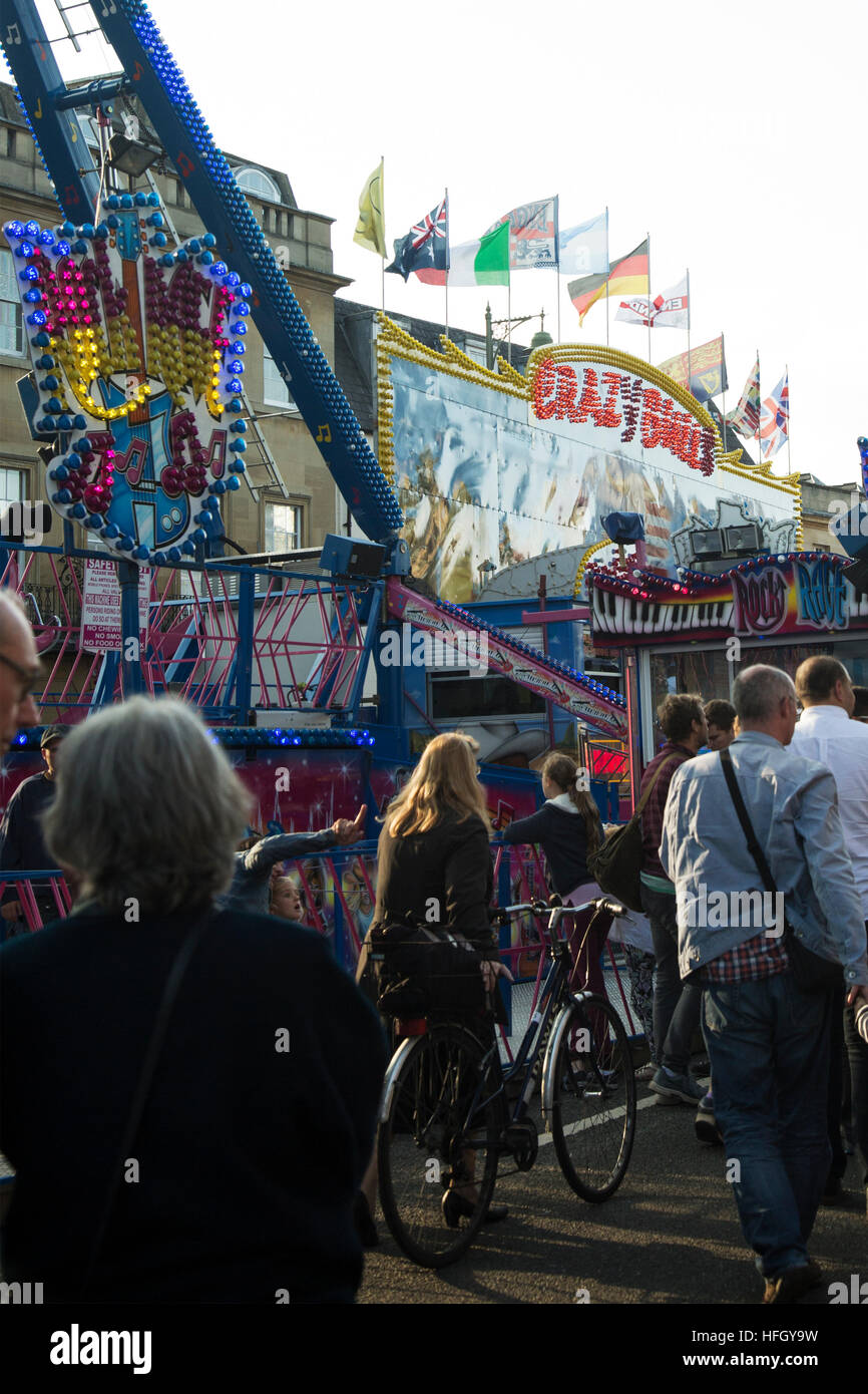 Eine Frau legt ihr Fahrrad durch die Massen an St Giles Fair Oxford Stockfoto