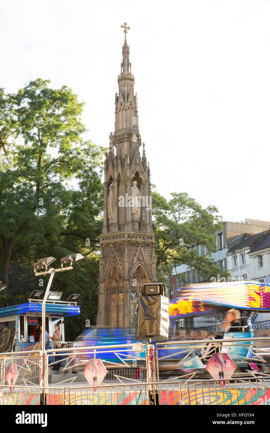 Die Gedenkstätte der Märtyrer, Oxford, umgeben von der Hektik der jährliche Herbst St Giles Fair mit einer Vielzahl von Fahrten zeigen Bewegung verwischen. Stockfoto