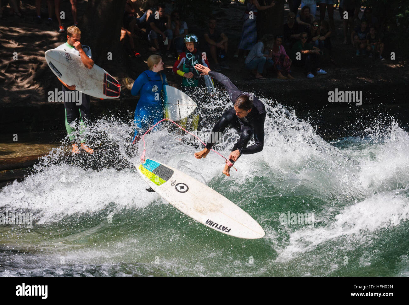 Surfer macht einen Sprung auf die künstliche stehende Welle im Eisbach in München Englisher Garten, Deutschland. Stockfoto