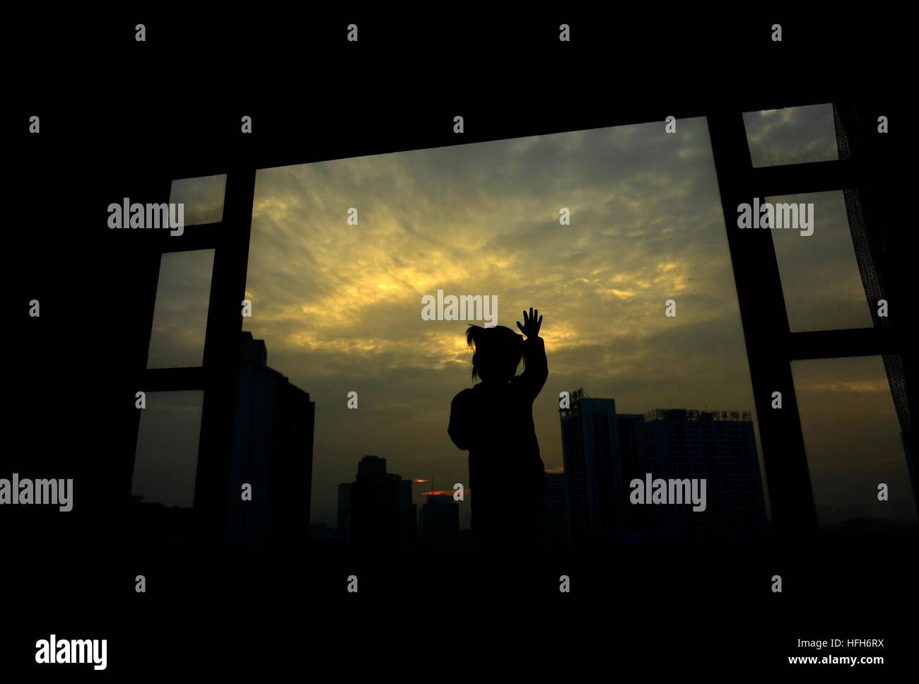 Qinzhou, Chinas autonomen Region Guangxi Zhuang. 1. Januar 2017. Eine Mädchen zeigt den Sonnenaufgang zu Hause in Qinzhou, Süd-China Autonome Region Guangxi Zhuang, 1. Januar 2017. © Lin Hong/Xinhua/Alamy Live-Nachrichten Stockfoto