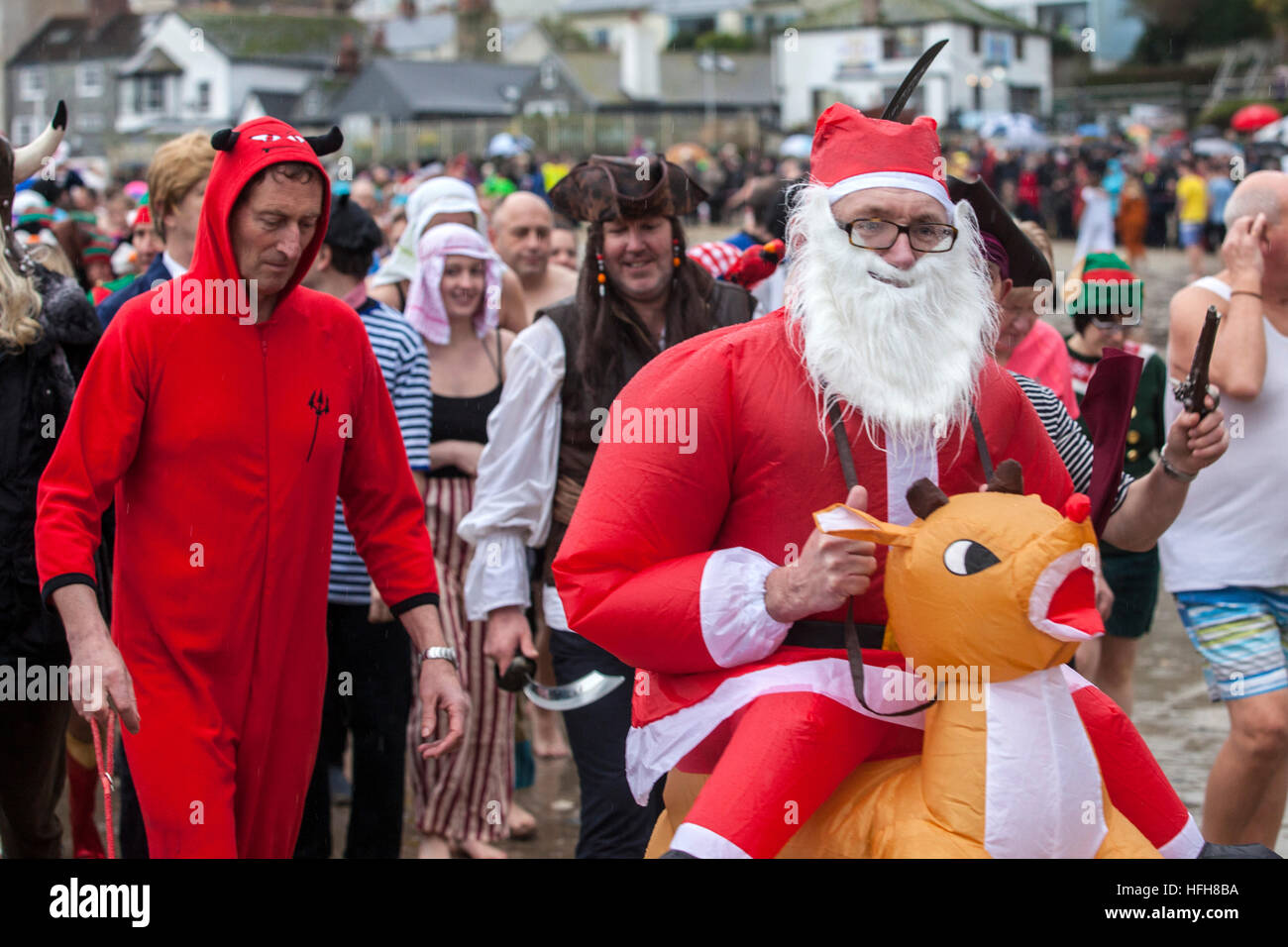 Hunderte erwies sich im Kostüm trotz Regen zur Teilnahme an der "Lyme Longe" - Tag des neuen Jahres schwimmen in Lyme Regis 2016 Stockfoto