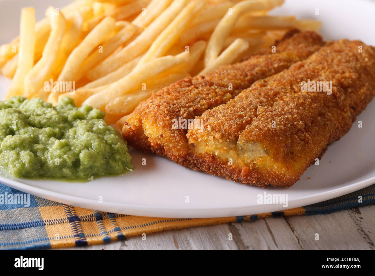 Englisch Essen: gebratene Fischfilets und Chips und Erbsen Püree Nahaufnahme auf einer Platte. horizontale Stockfoto