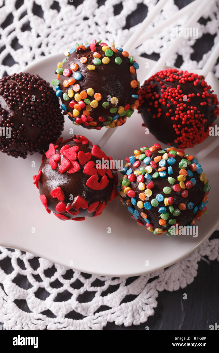 Bunte Pop Kuchen Closeup auf einem weißen Teller auf den Tisch. vertikale Stockfoto