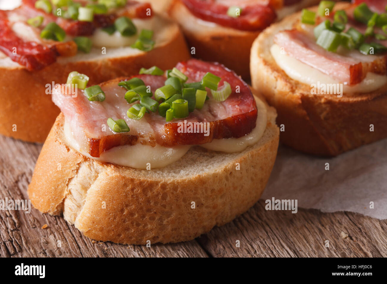 Crostini-Sandwiches mit Schinken und Mozzarella-Käse-Makro auf dem Tisch. horizontale Stockfoto