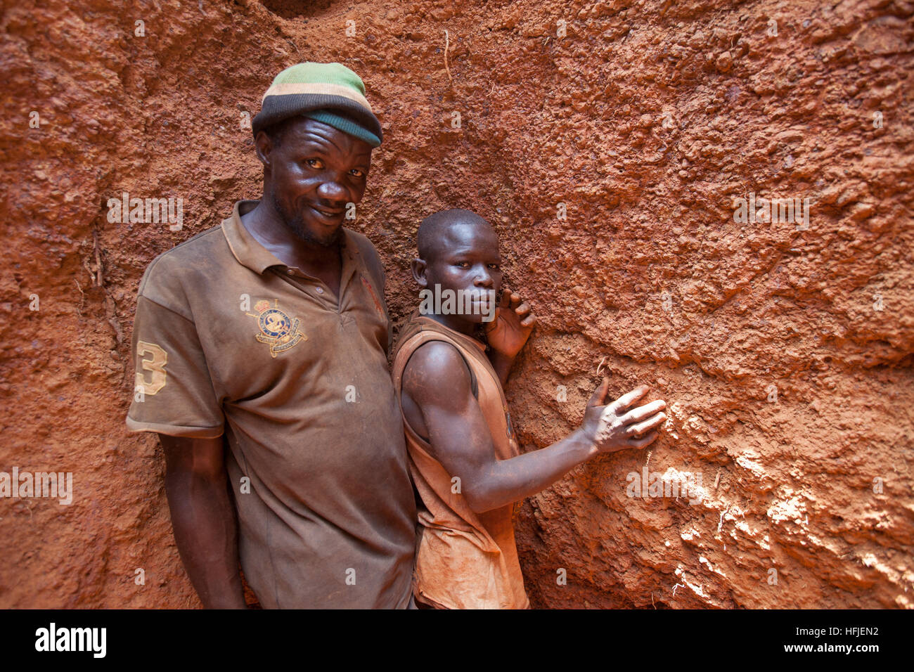 Sanana Mine, Guinea, 2. Mai 2015; Famoroba Camara, in seiner flachen Grube arbeiten mit dem Sohn seiner Freundin, Mamady Conde, 11. Stockfoto