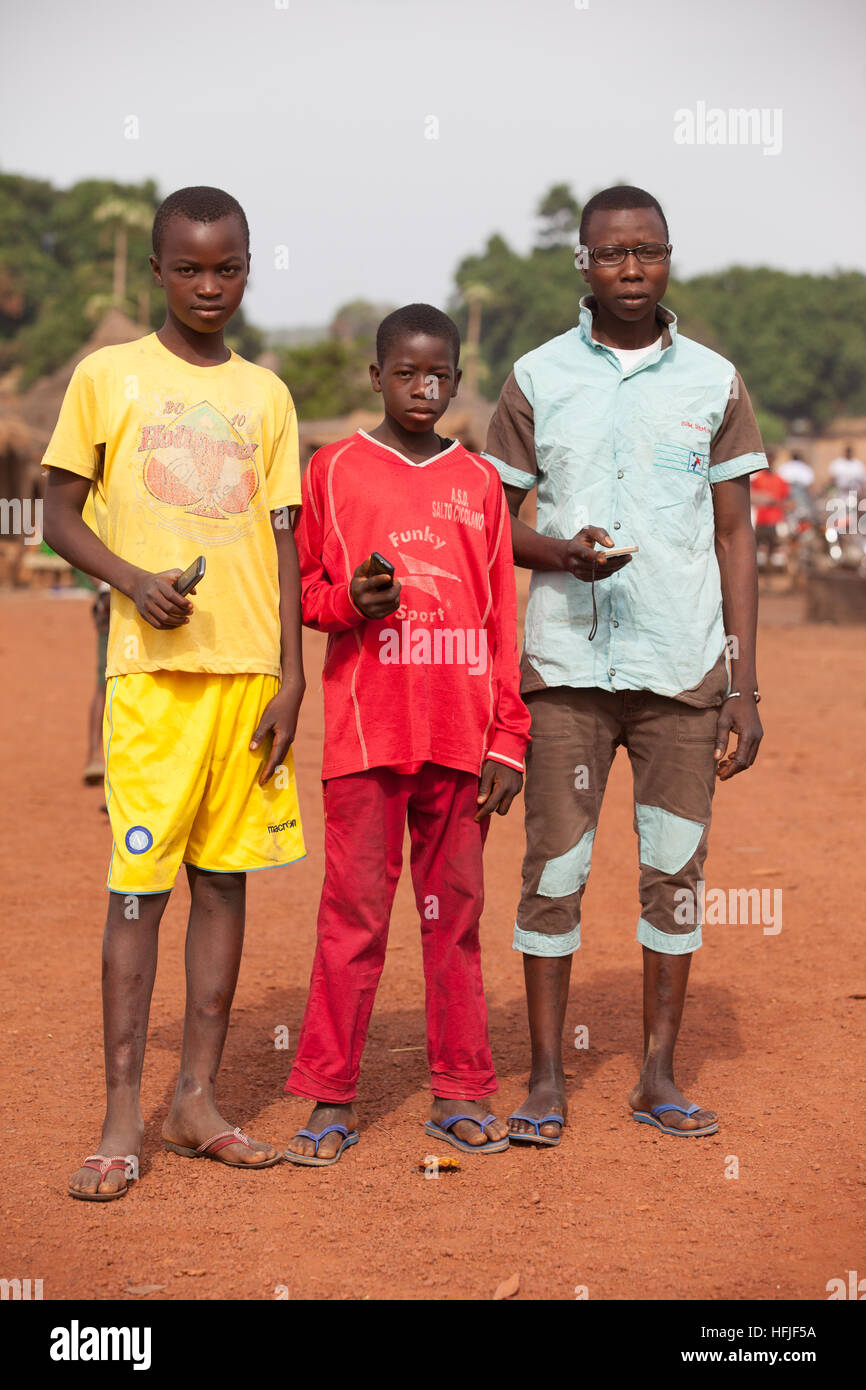 Koumban Dorf, Guinea, 2. Mai 2015; Jugendliche auf der Straße mit ihren Handys. Stockfoto