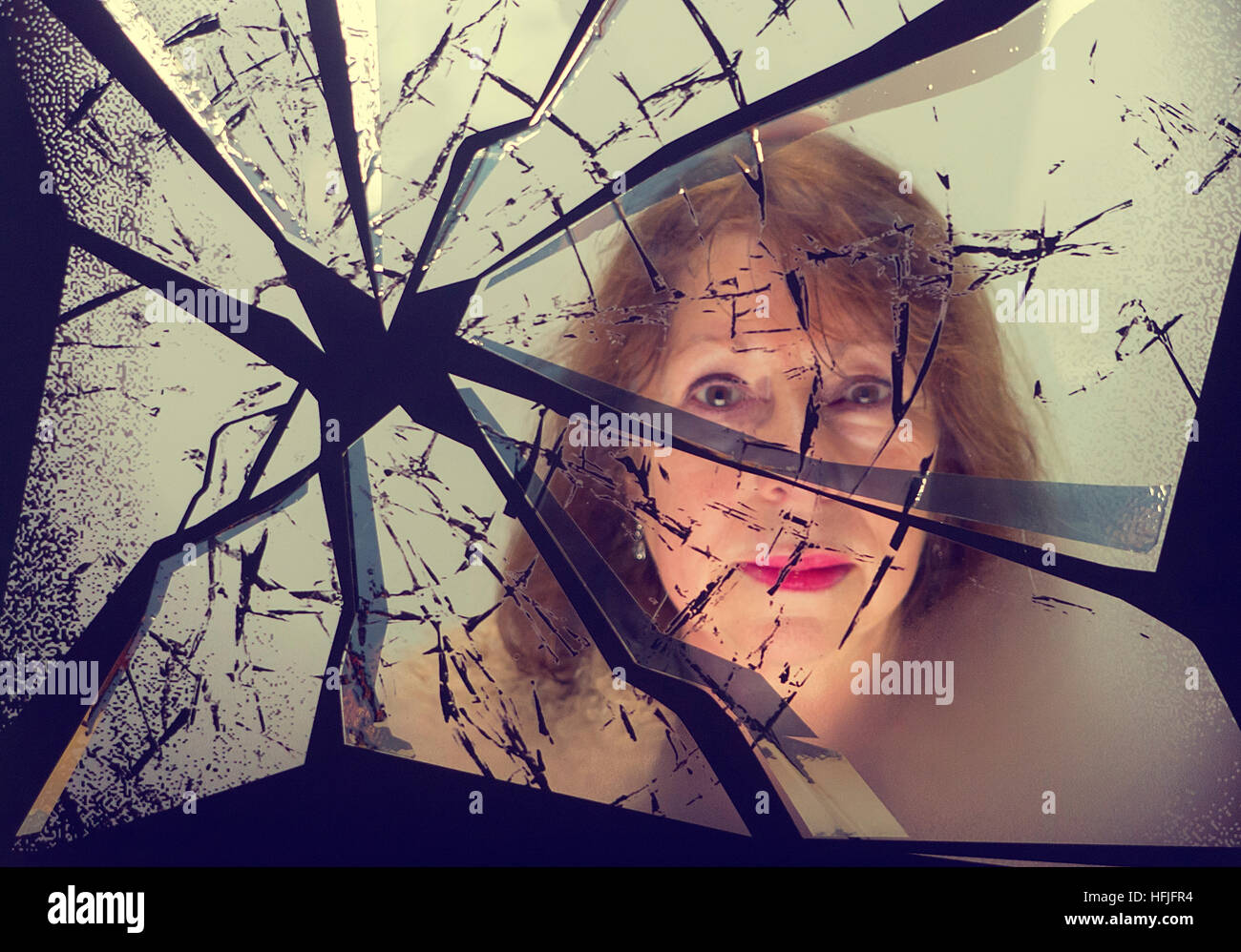 Reflexion einer Frau in einem zerbrochenen Spiegel Stockfoto