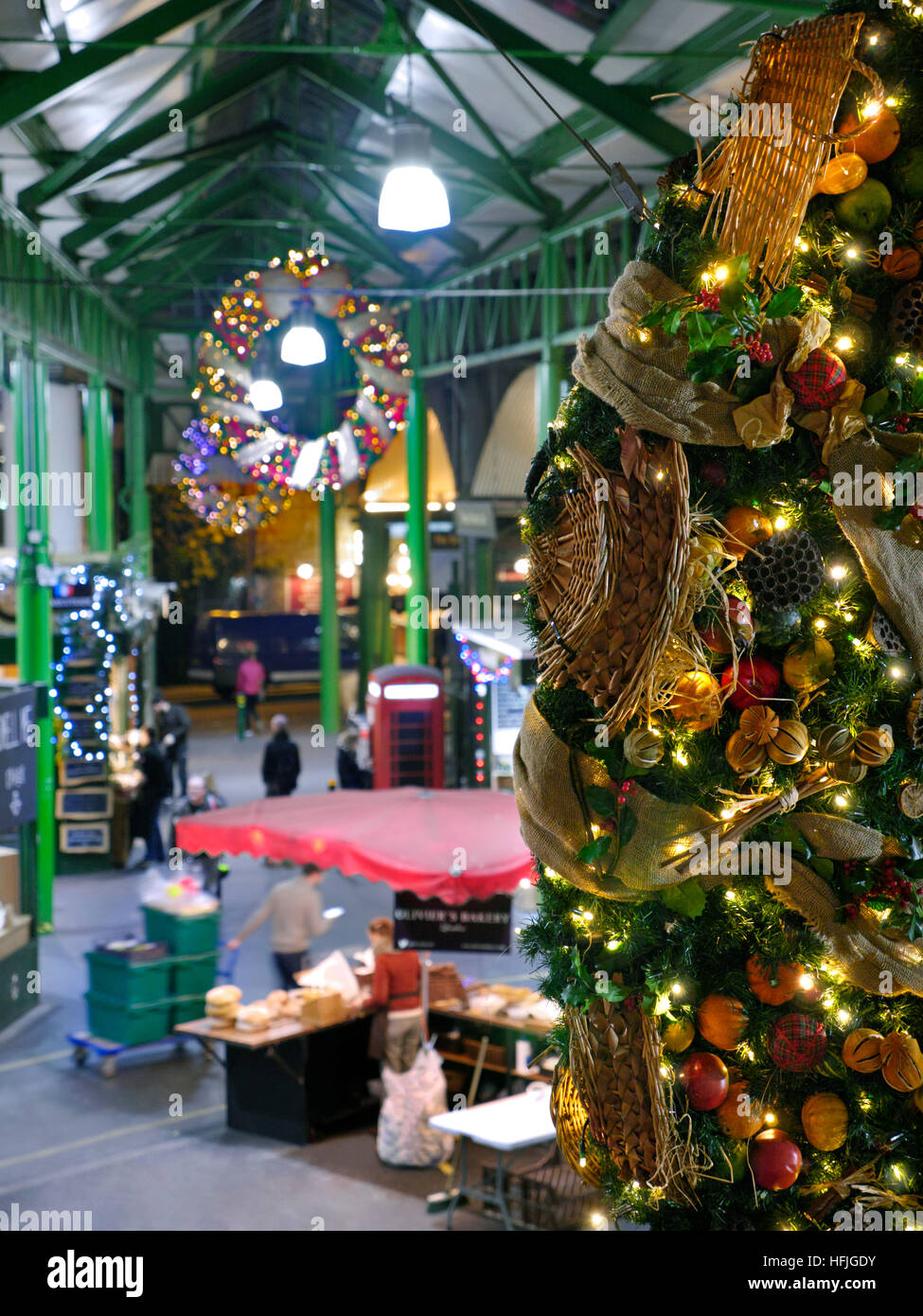 Erhöhte Sicht der späten Nacht Käse Marktstände und Verkostung Proben, Produkte unter dem Motto Weihnachten Kranz hängen im Vordergrund Borough Markt Southwark London SE1 Stockfoto
