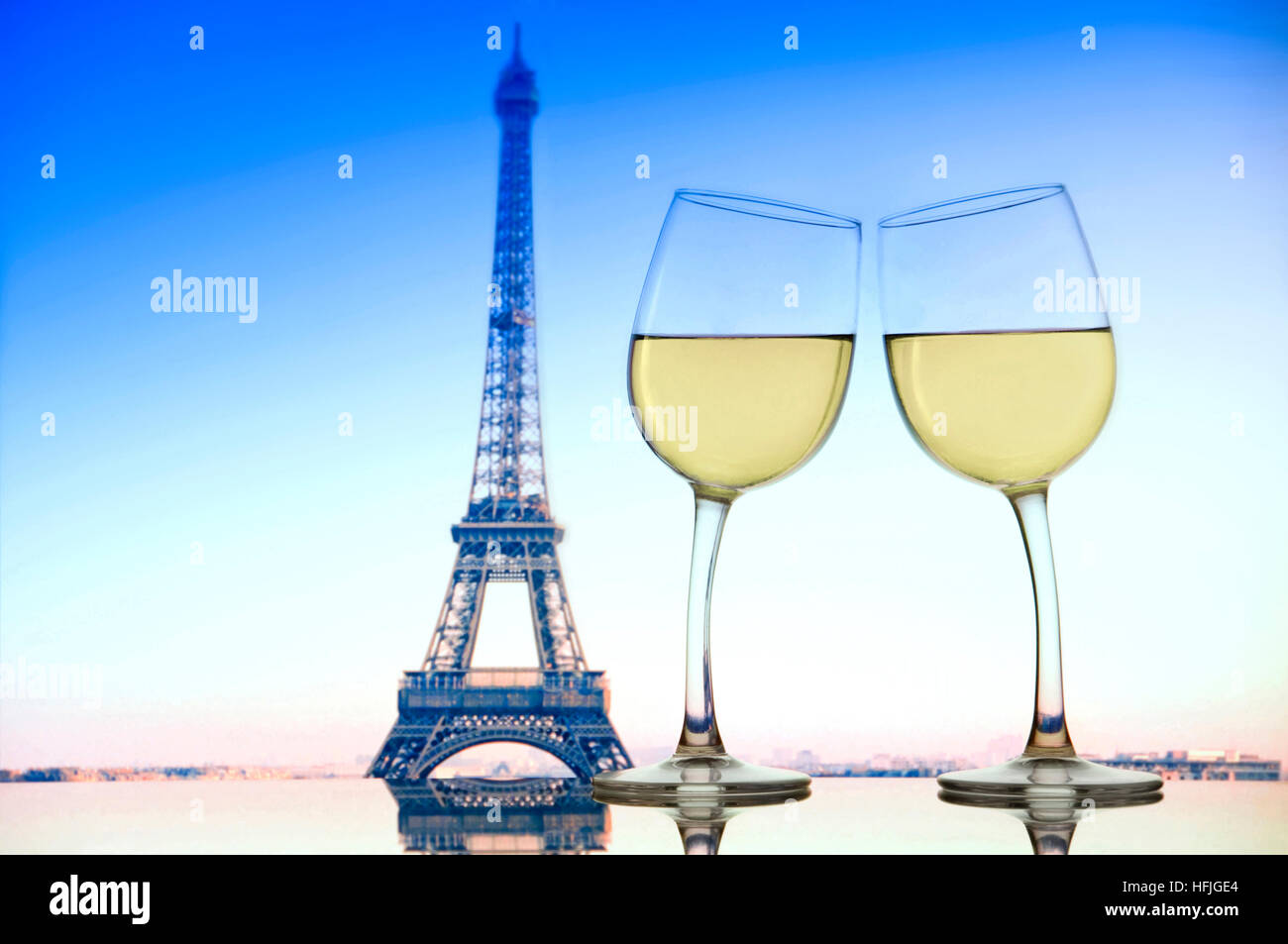PARIS LUSTIGES PAAR ROMANTIK "Cheers" mit zwei Weißweingläsern Sich auf dem Glastisch des Cafés mit Eiffel zueinander lehnen Turm hinter Paris Frankreich Stockfoto