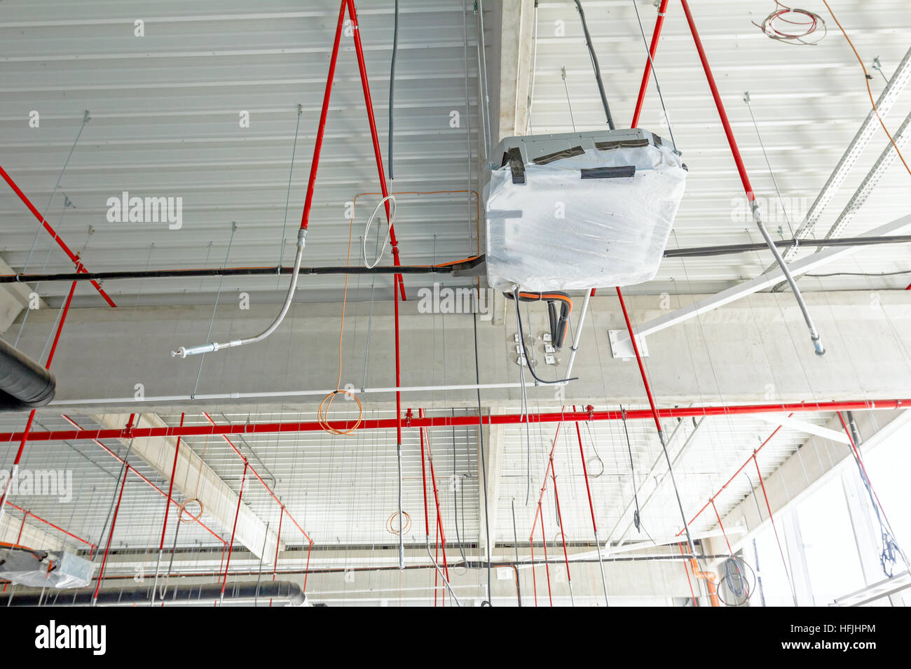Lüftungsrohre in Silber Isolierung Material und Feuer Sprinkler auf rote Rohr hängen von der Decke in neue Gebäude. Stockfoto