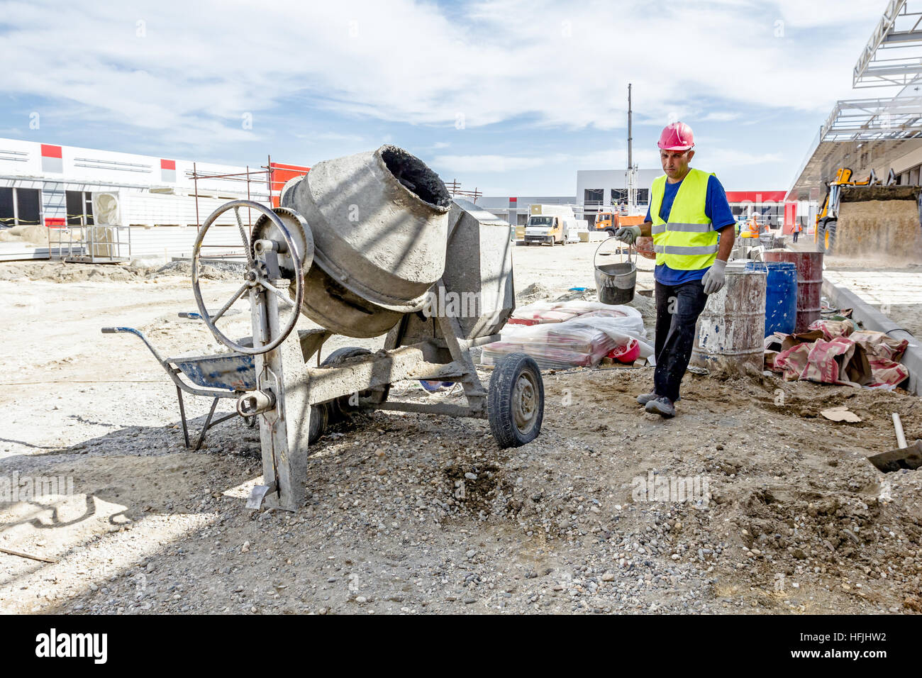 Zrenjanin, Vojvodina, Serbien - 29. Mai 2015: Betonmischer Maschine ist auf Baustelle mit Schubkarre, Werkzeuge, Sand und Zement Tasche. Stockfoto