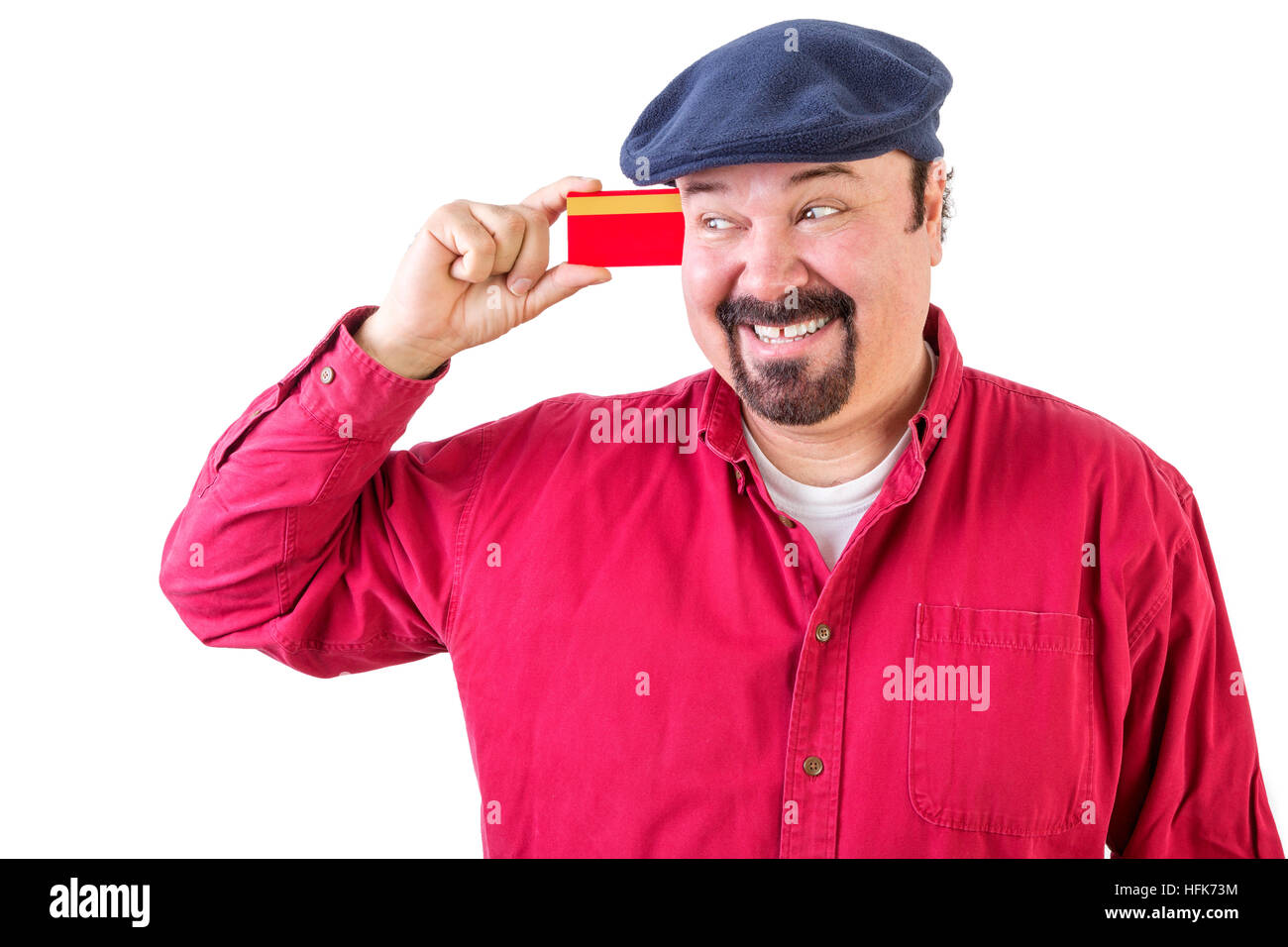 Fröhlichen Mann betrachtete seine Kreditkarte mit einem strahlenden Lächeln der Vorfreude, wie er all die Dinge vorstellt, die er kann gehen und kaufen, Oberkörper in ein rotes Hemd Stockfoto