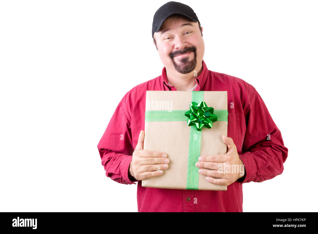 Stolzer single Mann in Hut und rot Langarm-Shirt hält ein Weihnachtsgeschenk verpackt in Goldpapier und Grünband Stockfoto