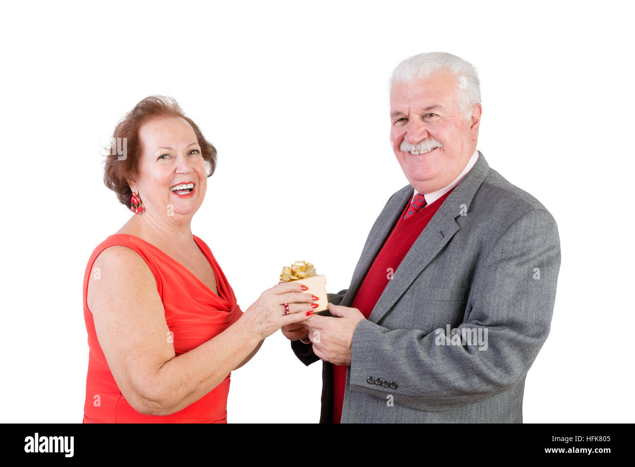 Älteres Ehepaar Valentinstag Geschenk austauschen und Lächeln in die Kamera vor einem weißen Hintergrund Stockfoto