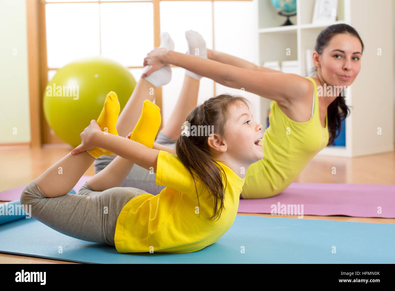 Mutter und Kind Yoga Übungen auf Teppich zu Hause. Stockfoto