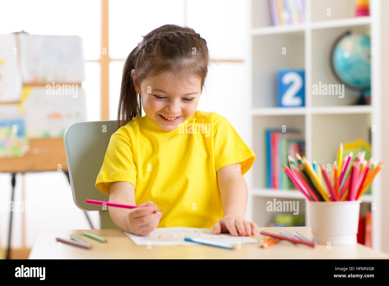 Niedliche kleine Vorschüler Kind Mädchen zeichnen Farbstiften zu Hause oder im studio Stockfoto
