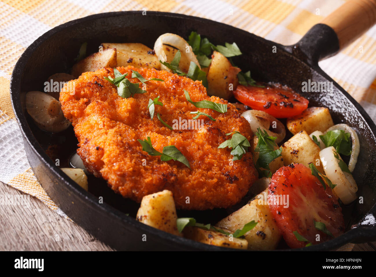 Hausgemachte panierte Deutsch Weiner Schnitzel mit gebratenem Gemüse in einer Pfanne Großaufnahme auf dem Tisch. horizontale Stockfoto