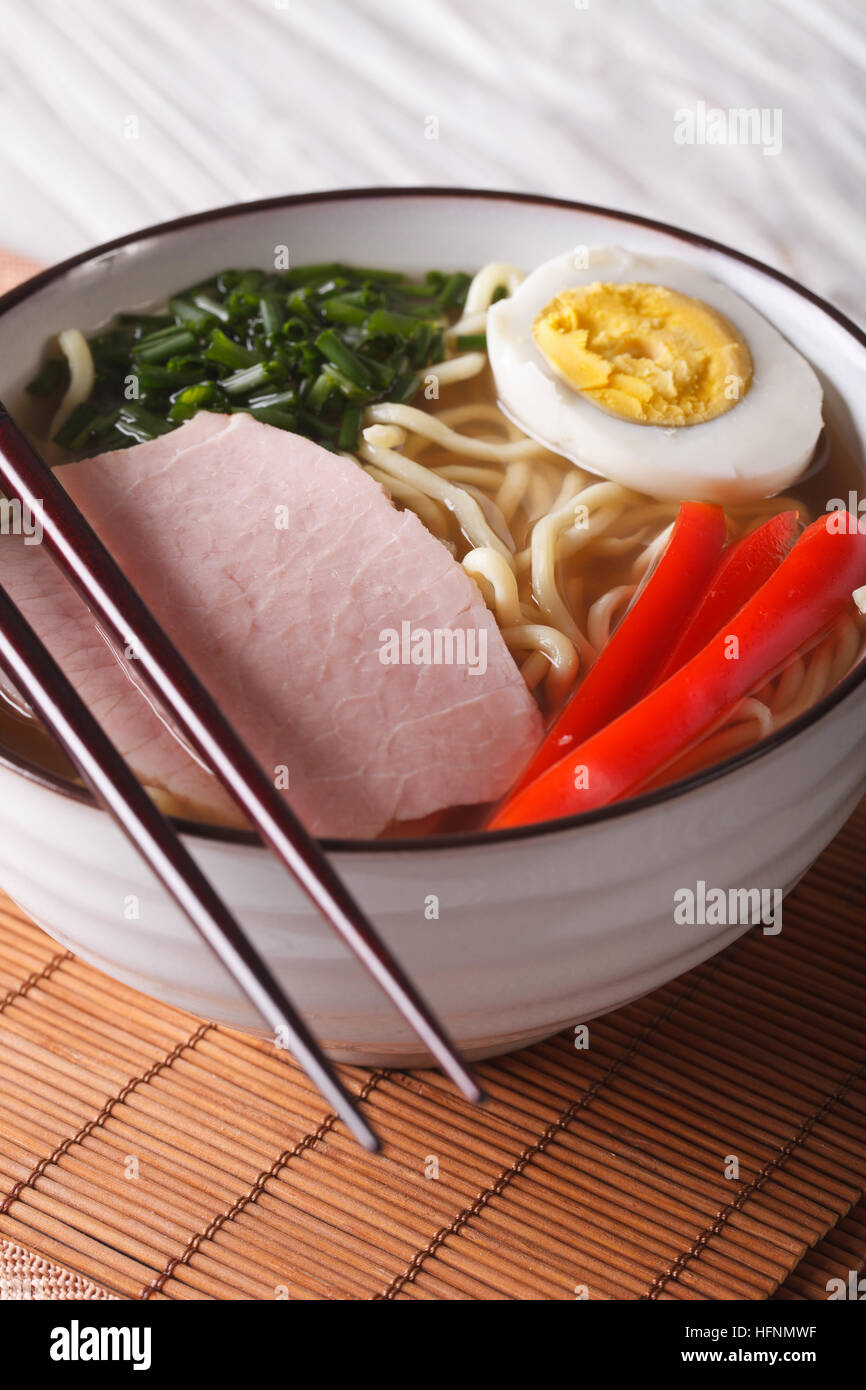 Ramen-Suppe mit Schweinefleisch, Gemüse und Ei in einer Schüssel hautnah. vertikale Stockfoto