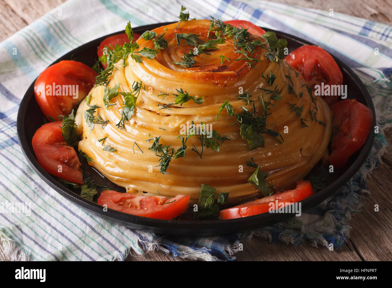 Schöne Timbale Nudeln mit Käse und Gemüse Nahaufnahme auf einer Platte. horizontale Stockfoto