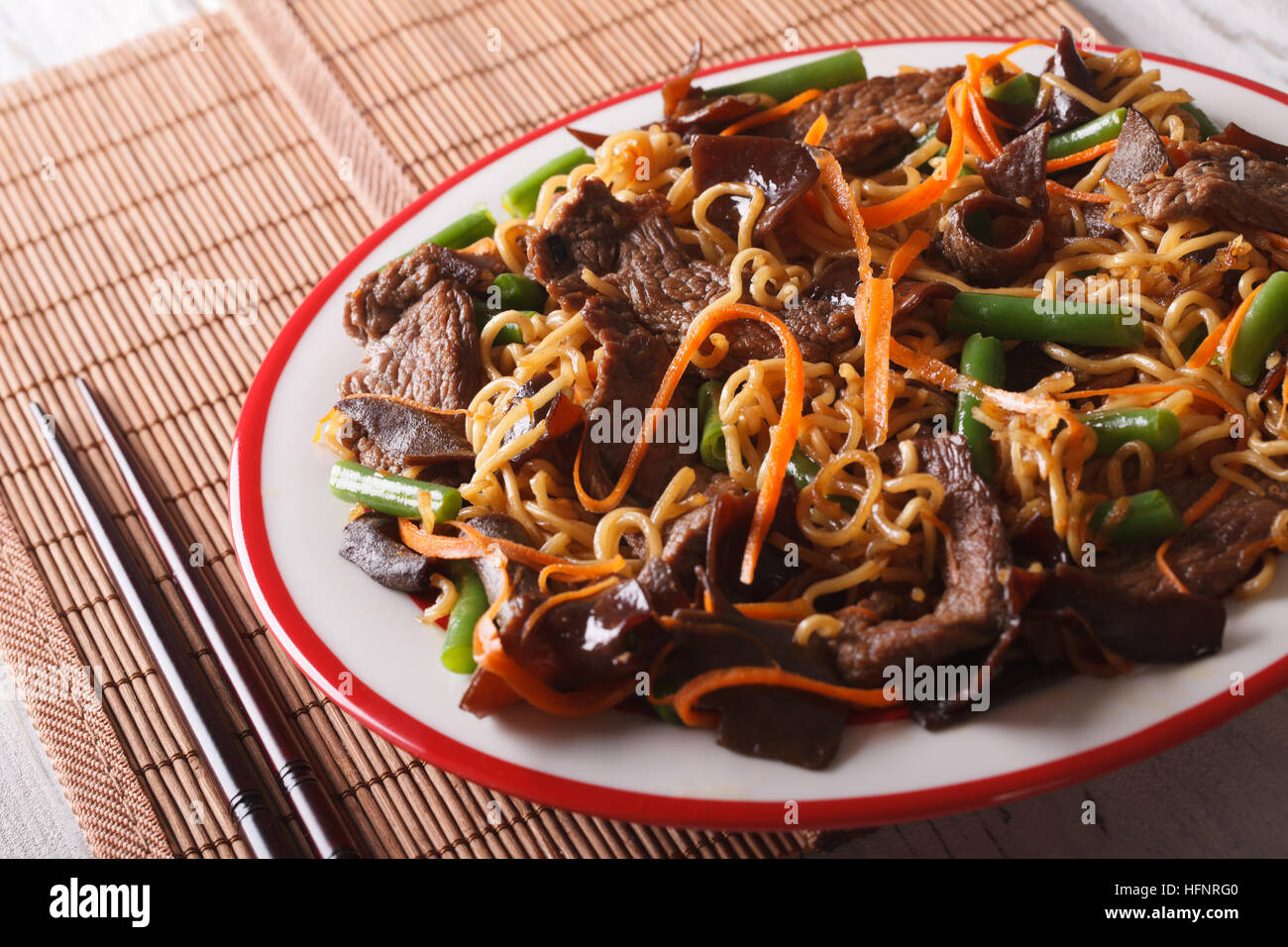 Chinesische Nudeln mit Rindfleisch, Mauser und Gemüse Nahaufnahme auf einer Platte. horizontale Stockfoto