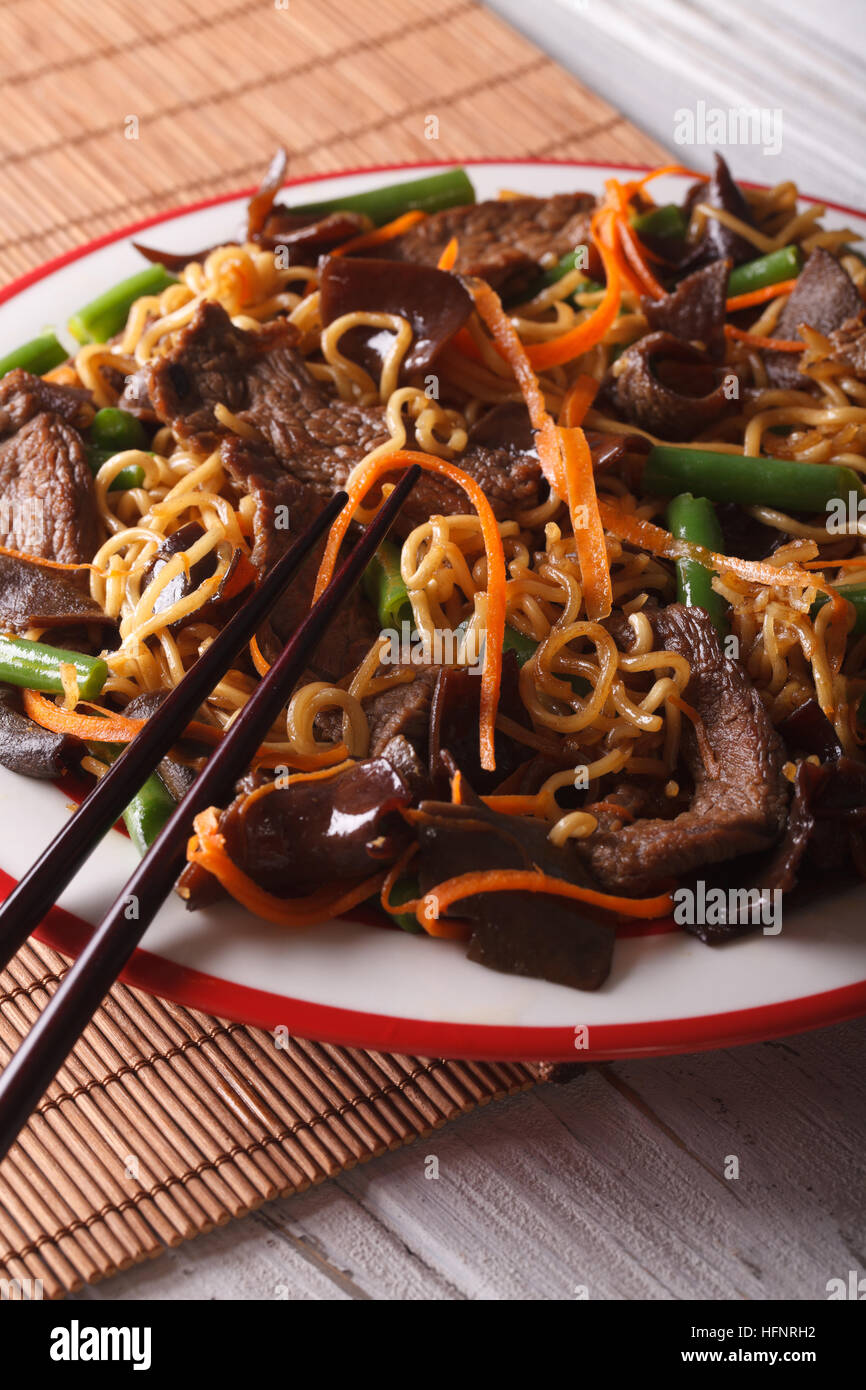 Lo Nudeln Mein Chinesisch mit Rindfleisch und Mauser Makro auf einem Teller. Vertikal Stockfoto