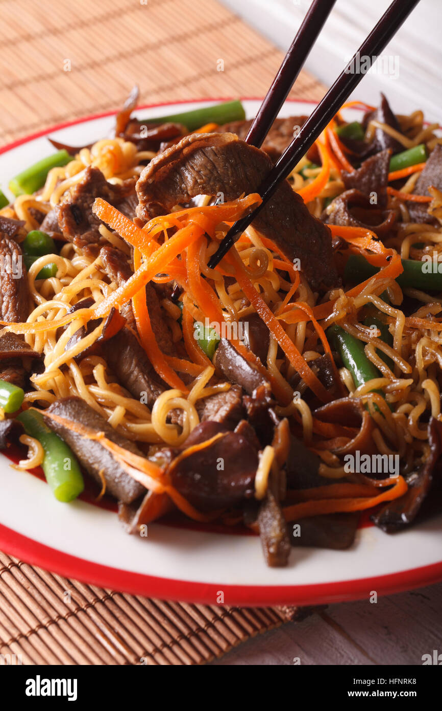 Lo Nudeln Mein Chinesisch mit Rindfleisch und schwarze Pilz Makro auf einem Teller. vertikale Stockfoto