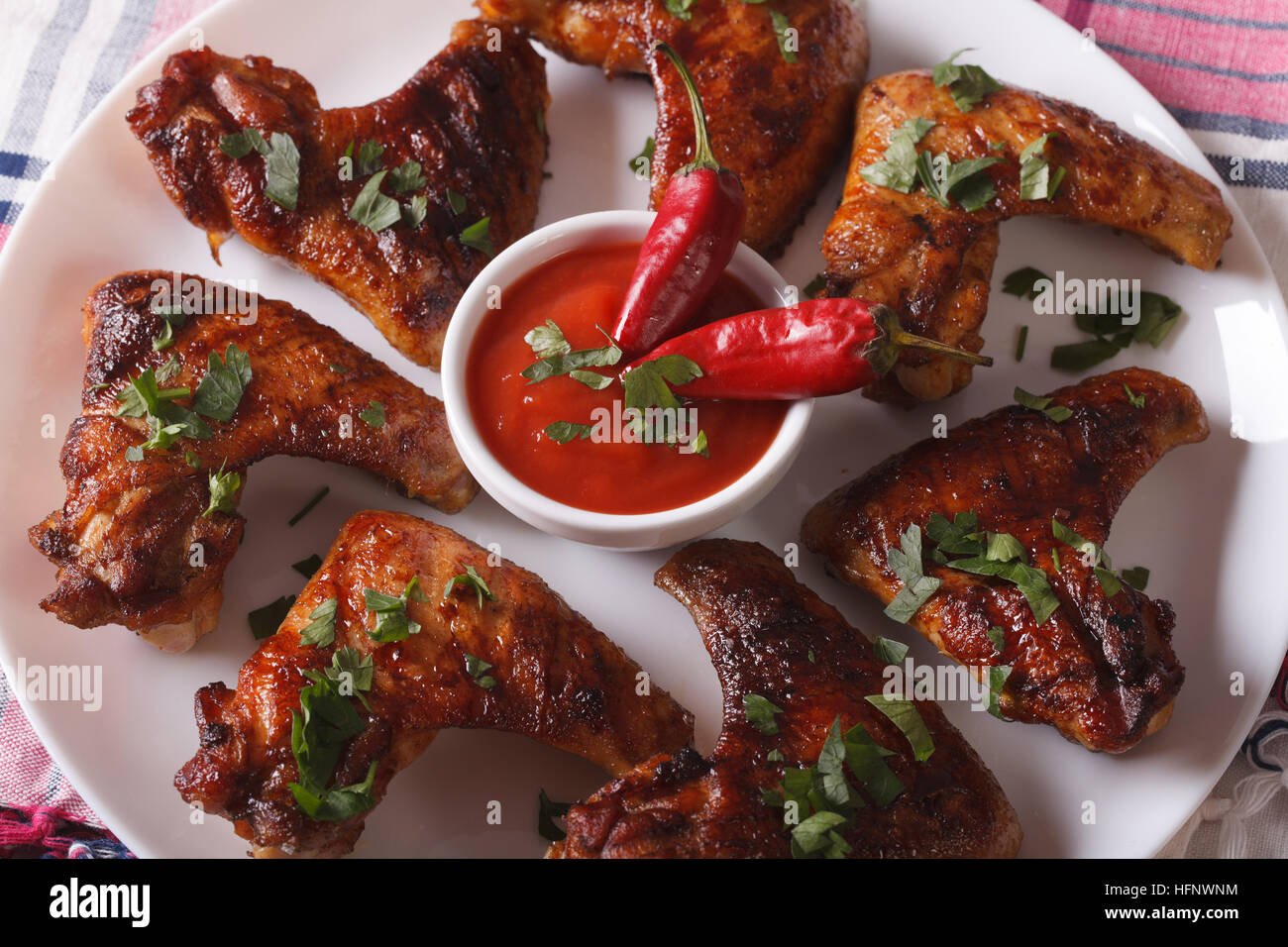 Gegrillte Hühnerflügel mit Chili-Sauce auf einer Platte Makro. horizontale Ansicht von oben Stockfoto
