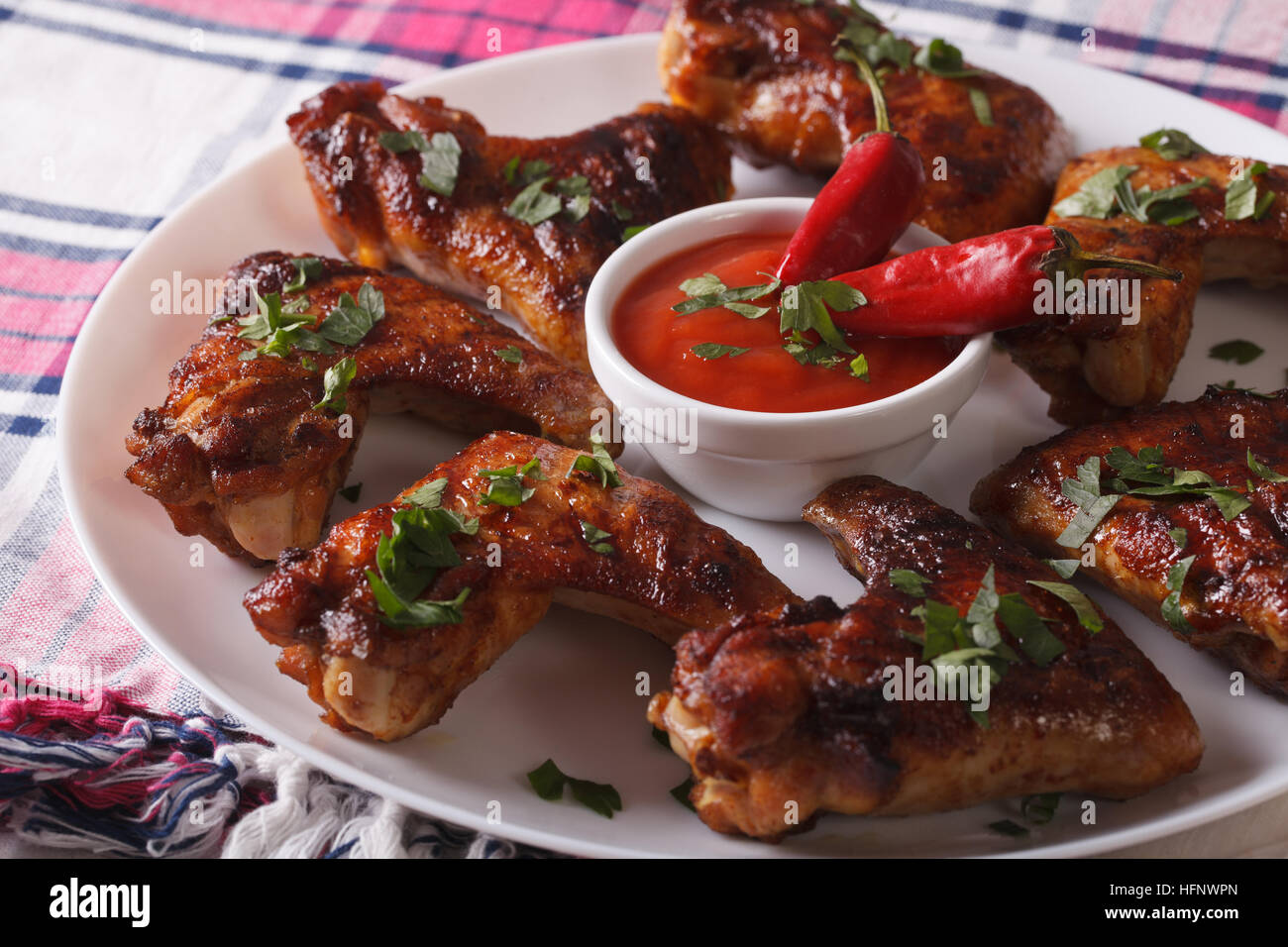 Gegrillte Hühnerflügel mit Chili-Sauce auf einer Platte Nahaufnahme heiß. horizontale Stockfoto