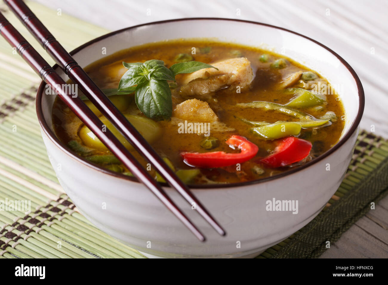 Suppe grünes Curry Huhn close-up auf den Tisch und Stäbchen. Horizontale Stockfoto