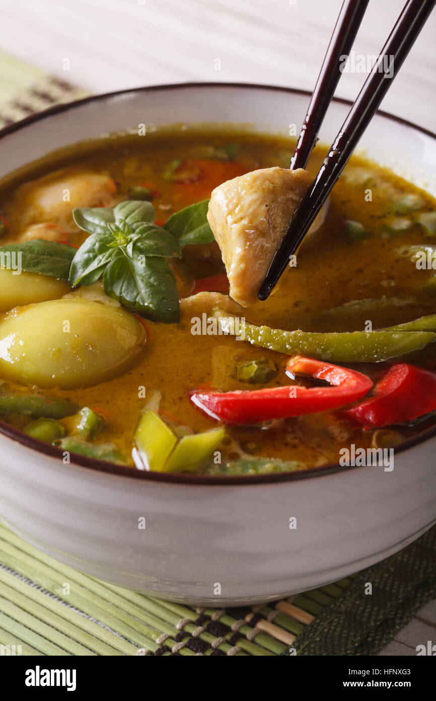 Grünem Thai-Curry mit Huhn in einer Schüssel weiß-Makro. vertikale Stockfoto