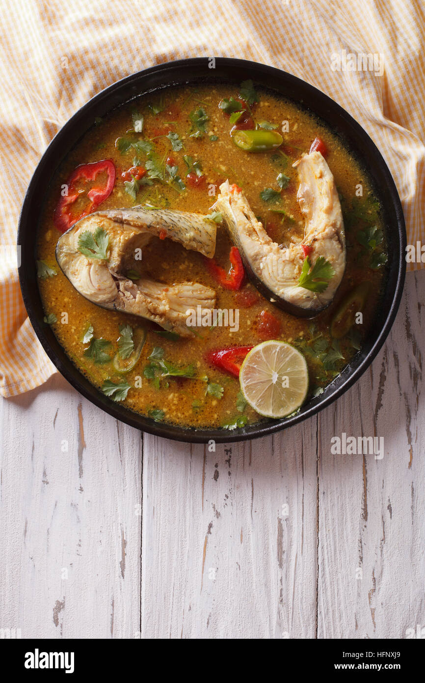 Köstlich würziger Fisch curry mit Koriander auf dem Tisch. vertikale Ansicht von oben Stockfoto
