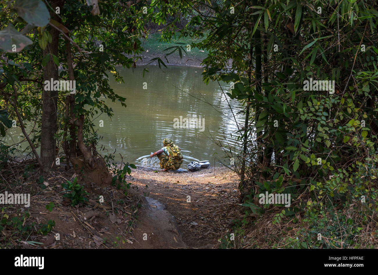 Ländliche indische Frau wäscht ihre Utensilien in einem Dorf Teich an bankura, West Bengal, Indien. Stockfoto