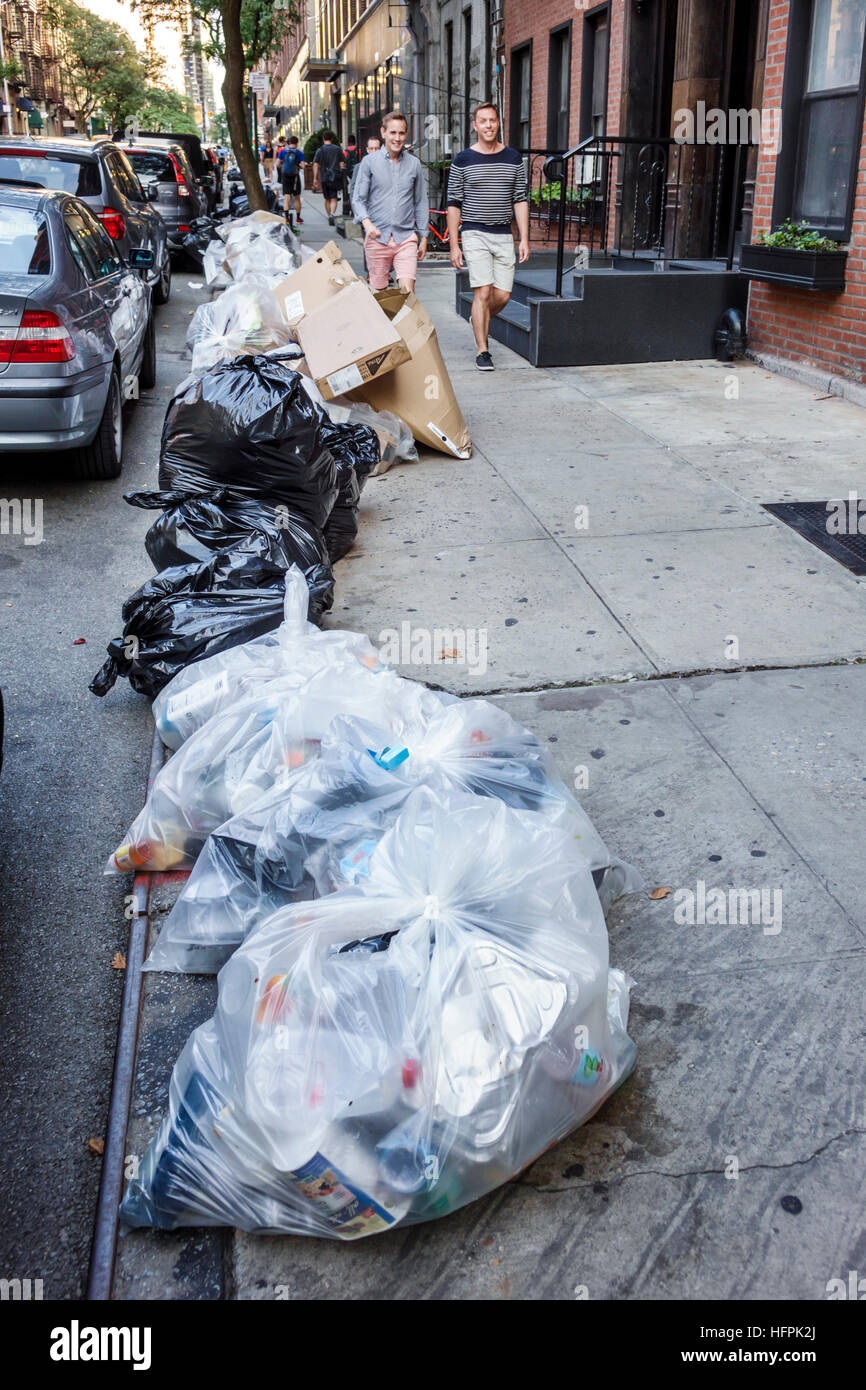 New York City, New York NYC Manhattan, Bürgersteig, Müll, Plastiktüten, Bordsteinsammlung, Erwachsene, Erwachsene, Männer, Männer, die vorbeigehen, NY160721105 Stockfoto