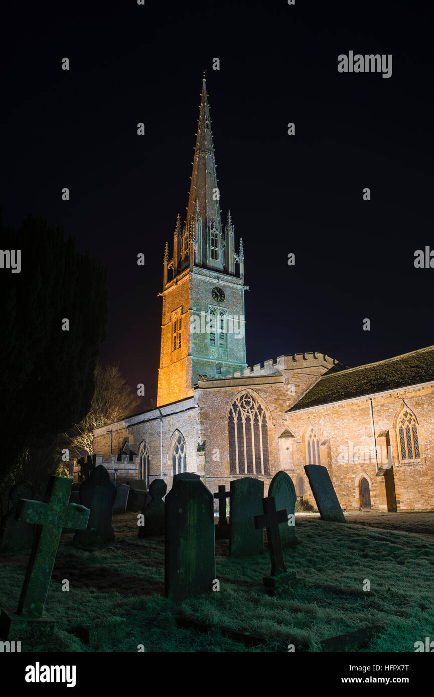 St. Peter & Paul Kirche beleuchtet bei Nacht im Dezember. Könige Sutton, Nr Banbury, Northamptonshire, England Stockfoto