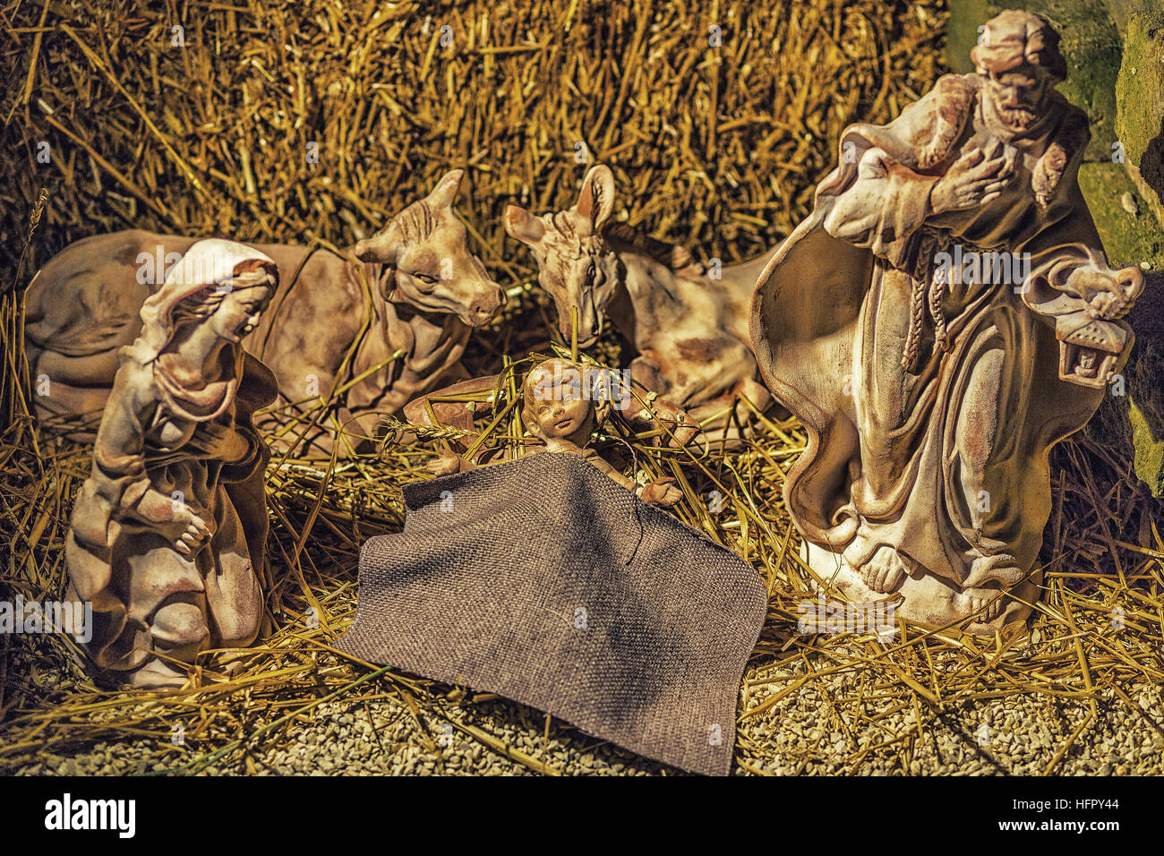 Statuen in eine Weihnachtskrippe, der seligen Jungfrau Maria und St. Joseph wachen über die Heiligen Jesuskind in einer Krippe in das Stroh als Ochsen und Stockfoto