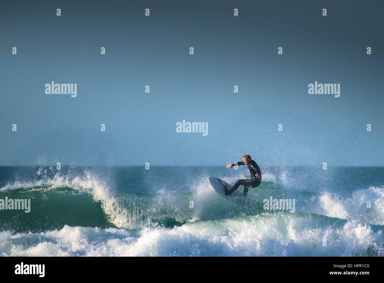 Ein Surfer in einer spektakulären Aktion auf den Fistral in Newquay, Cornwall, England. Stockfoto