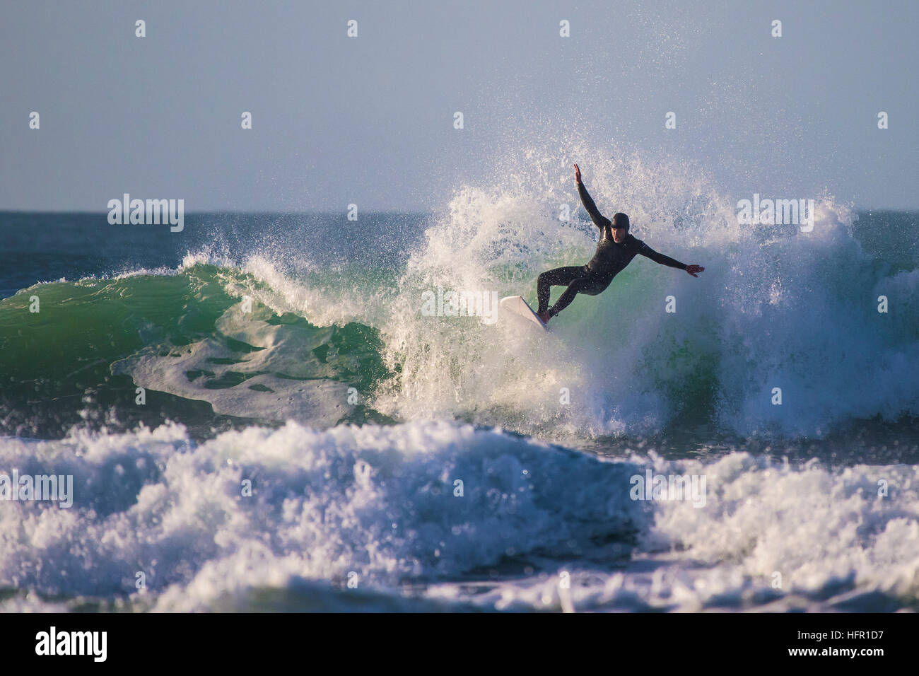 Ein Surfer in einer spektakulären Aktion auf den Fistral in Newquay, Cornwall, England. Stockfoto