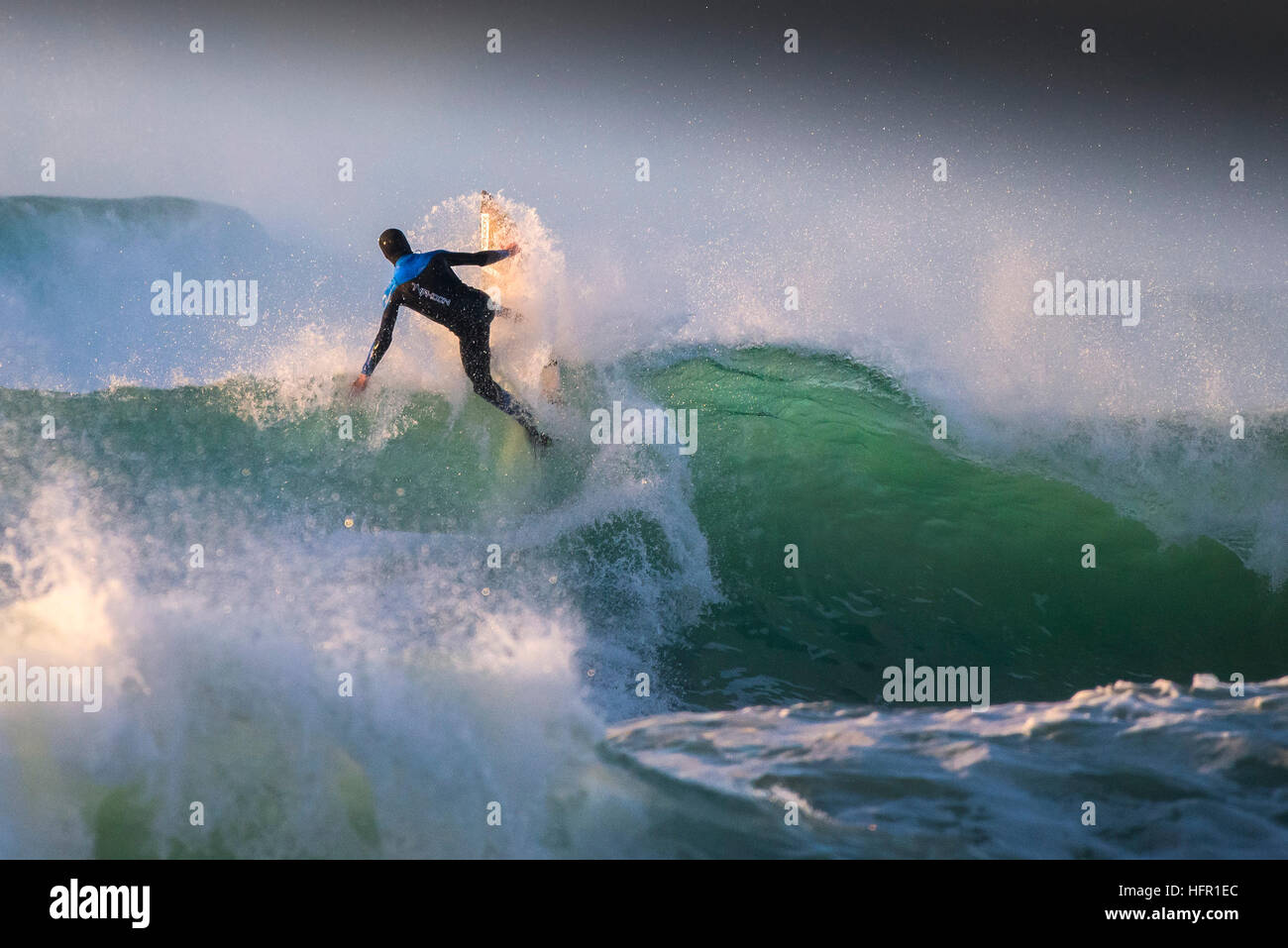 Ein Surfer in einer spektakulären Aktion auf den Fistral in Newquay, Cornwall, England. Stockfoto