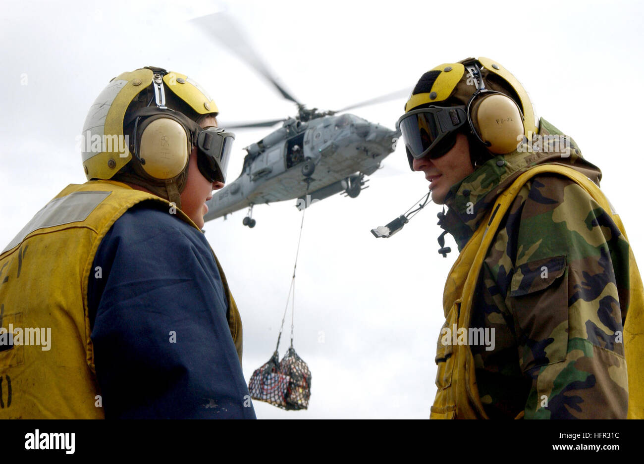 060301-N-7571S-006-Mittelmeer (1. März 2006) - Segler an Bord Flugzeugträger der Nimitz-Klasse USS Theodore Roosevelt (CVN-71) zugewiesen auf dem Flugdeck zu kommunizieren, wie ein HH - 60 H Seahawk Hubschrauber zugewiesen, der "Dreizack" der Anti-Submarine Squadron drei (HS-3) eine vertikale Nachschub (VERTREP führt). USS Theodore Roosevelt (CVN-71) und eingeschifften Carrier Air Wing acht (CVW-8) werden derzeit auf eine regelmäßige Bereitstellung Gefahrenabwehr Operationen durchführen. Foto: U.S. Navy Lithograph 3. Klasse Jonathan Snyder (freigegeben) US Navy 060301-N-7571S-006 Segler-Assi Stockfoto