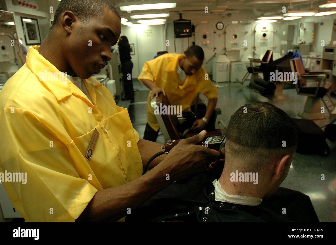 060412-N-7711S-040 Persischen Golf (12. April 2006) - Schiffs Serviceman 3. Klasse Bobby Walker gibt einem seiner Kameraden eine Verkleidung in der Barbershop an Bord der Flugzeugträger der Nimitz-Klasse USS Ronald Reagan (CVN-76). Reagan und eingeschifften Carrier Air Wing One vier (CVW-14) werden derzeit im Rahmen einer routinemäßigen Rotation der US-Seestreitkräfte zur Unterstützung der globalen Krieg gegen den Terrorismus sowie die Durchführung von Maritime Security Operations (MSO) in der Region eingesetzt. Foto: U.S. Navy PhotographerÕs Mate Flieger Christine Singh (freigegeben) US Navy 060412-N-7711S-040 Schiff Serviceman 3. Klasse Bobby Walke Stockfoto
