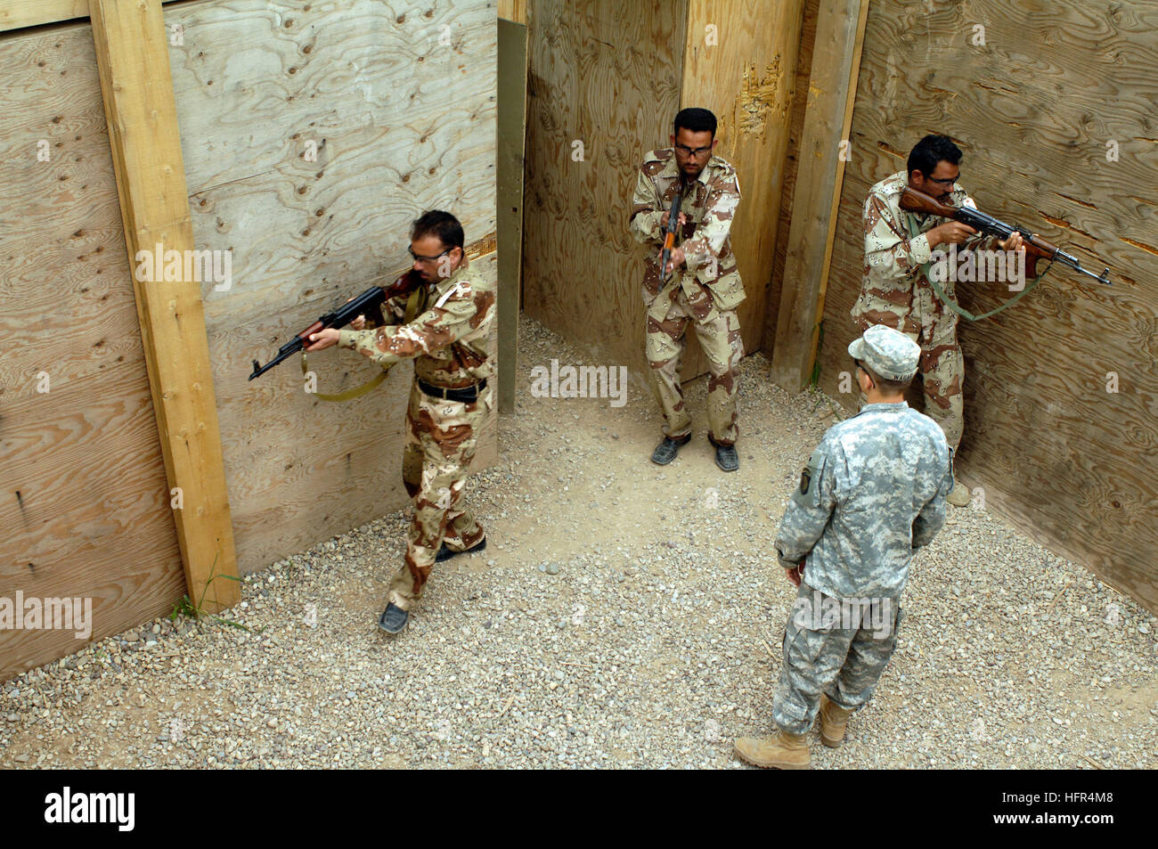 060412-N-4614W-044 vorwärts Operating Base McHenry, Irak (12. April 2006) - Irak Soldaten aus einem 5. Bataillon Suche durch ein Kill-Haus als Armee Spc. Nate Wagar beobachtet, bei militärischen Operationen in urbanem Gelände (MOUT). Die einwöchige (MOUT) Kurs ist repetitiv und rasanten geben die irakischen Soldaten Muskelgedächtnis, erfolgreich eine Residenz, schnell und sicher einzugeben. Der Kurs beinhaltet Einschießen von Waffen, live Kill-Haus Brandszenarien und montierte Waffensysteme. Wagar ist, Stabskompanie, 1. Bataillon, 327th Infanterie-Regiment, vorwärts-bereitgestellt von ft. Campbell zugeordnet, Stockfoto