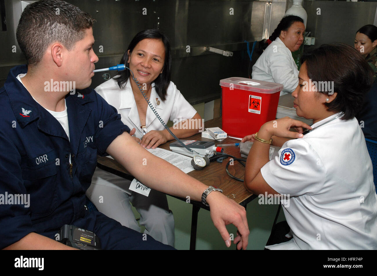 060531-N-3931M-012 Zamboanga, Philippinen (31. Mai 2006) - Krankenschwestern für die philippinischen nationalen Rotkreuz, nimmt einen Temperaturwert und andere wichtige Informationen aus der Navy Petty Officer 3rd Class Christopher Orr aus San Diego, Kalifornien, während eine rote Kreuz Blut Fahrt an Bord der US Military Sealift Command (MSC)-Lazarettschiff USNS Mercy (T-AH 19) bei einem Besuch der Stadt bei einem geplanten humanitären Besuch. Am 17. September 1947 als ein Mitglied der Liga der Rotkreuz- und Rothalbmond-Föderation zugelassen, unterstützt philippinischen nationalen Roten Kreuzes die Regierung zu Soforthilfe für die Opfer in Stockfoto