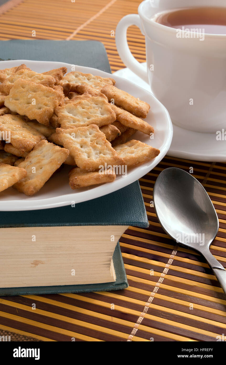 Weißen Teller mit Keksen auf dem alten Buch mit geringer Tiefe des Fokus. Stockfoto