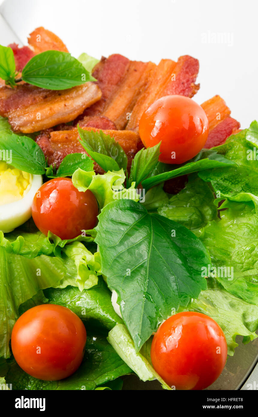 Detail einer Platte mit Cherry-Tomaten, Kräuter, Olivenöl, Eiern und Speck hautnah mit unscharfen Hintergrund Stockfoto