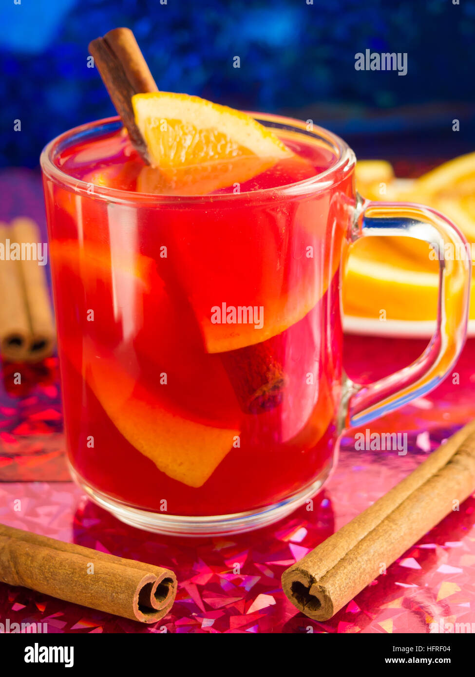 Transparente Becher mit Zitrusfrüchten Glühwein, Zimt und Orange, hell glänzenden Hintergrund Unschärfe mit geringer Tiefe des Fokus Stockfoto